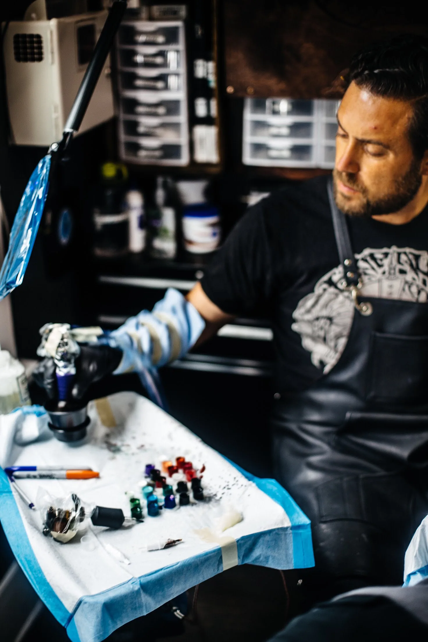 Terry Ribera preparing ink at his workstation, Remington Tattoo San Diego